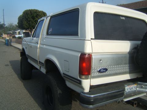 1988 Ford Bronco - Rear view of a white Ford Bronco with a diamond plate accent on the tailgate.