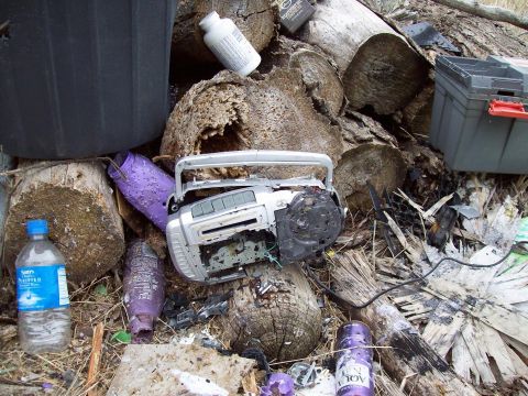 2000 Mercury Grand Marquis - Debris pile includes a damaged boombox, plastic bottles, and a toolbox.