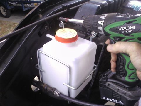 1978 Ford Bronco - Installing a new windshield washer fluid reservoir with a power drill.