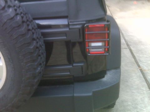 2008 Jeep Wrangler - The rear tail light of a Jeep Wrangler is protected by a black metal guard.