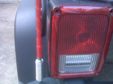2008 Jeep Wrangler - Close-up of the rear tail light assembly and a red antenna on a Jeep Wrangler.