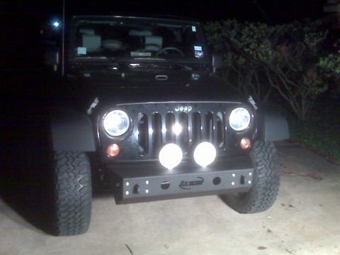 2008 Jeep Wrangler - A black Jeep Wrangler is parked at night, a custom front bumper with auxiliary lights.