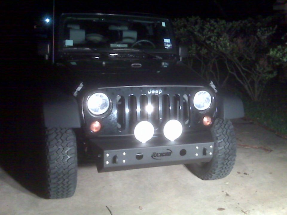 Front view of black Jeep Wrangler with Rancho bumper and two round lights