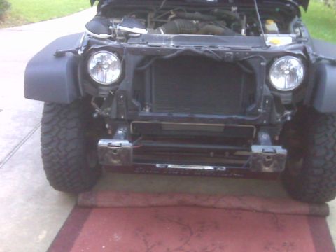 2008 Jeep Wrangler - Front view of a Jeep Wrangler with the hood up and bumper removed, revealing the engine and radiator.