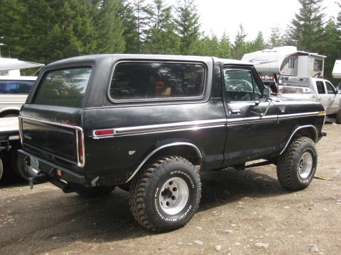 1979 Ford Bronco - This Ford Bronco is parked outdoors with trees and RVs visible in the background.