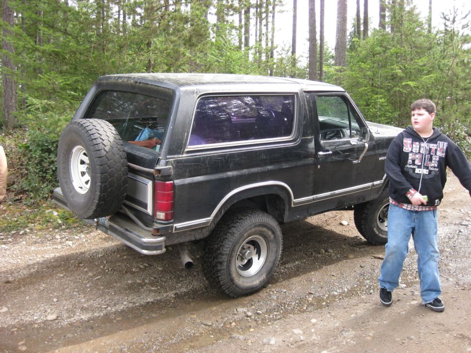 Black 1979 Ford Bronco with spare tire on rear, side view