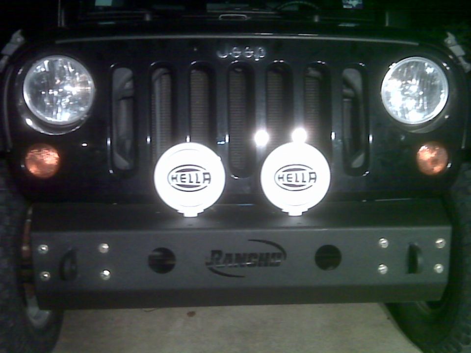 Black Jeep Wrangler front with aftermarket Rancho bumper and Hella lights