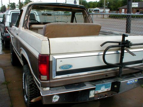 1983 Ford Bronco - Rear view of a 1983 Ford Bronco, showing its two-tone paint scheme and spare tire carrier.