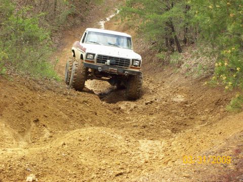 1978 Ford Bronco - A lifted 1978 Ford Bronco navigates a challenging muddy trail, its off-road capabilities.