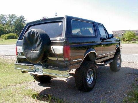1983 Ford Bronco - This black Ford Bronco is shown from the rear, a spare tire cover and a visible license plate.