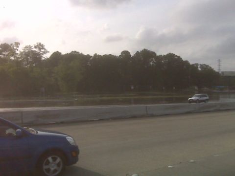 2008 Jeep Wrangler - A silver SUV is seen driving on a road, with a blue car partially visible in the foreground.