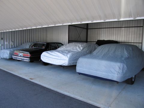 1991 Ford LTD Crown Victoria - A black 1991 Ford Crown Victoria LTD is parked in a row with other vehicles under covers.