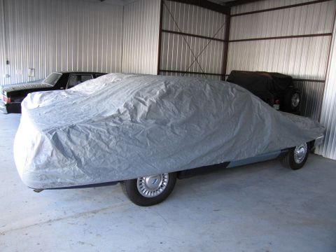 1991 Ford LTD Crown Victoria - Two cars and a Jeep are stored inside a metal building, one car is completely covered.
