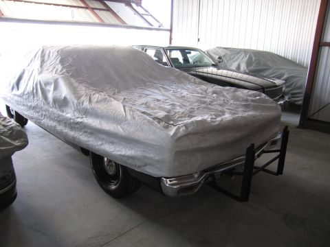 1991 Ford LTD Crown Victoria - Multiple vehicles are stored indoors, covered by protective sheeting, in a garage setting.