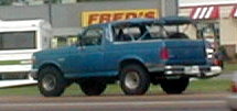1983 Ford Bronco - Side view of a blue Ford Bronco, likely from the late 1980s, parked outdoors.