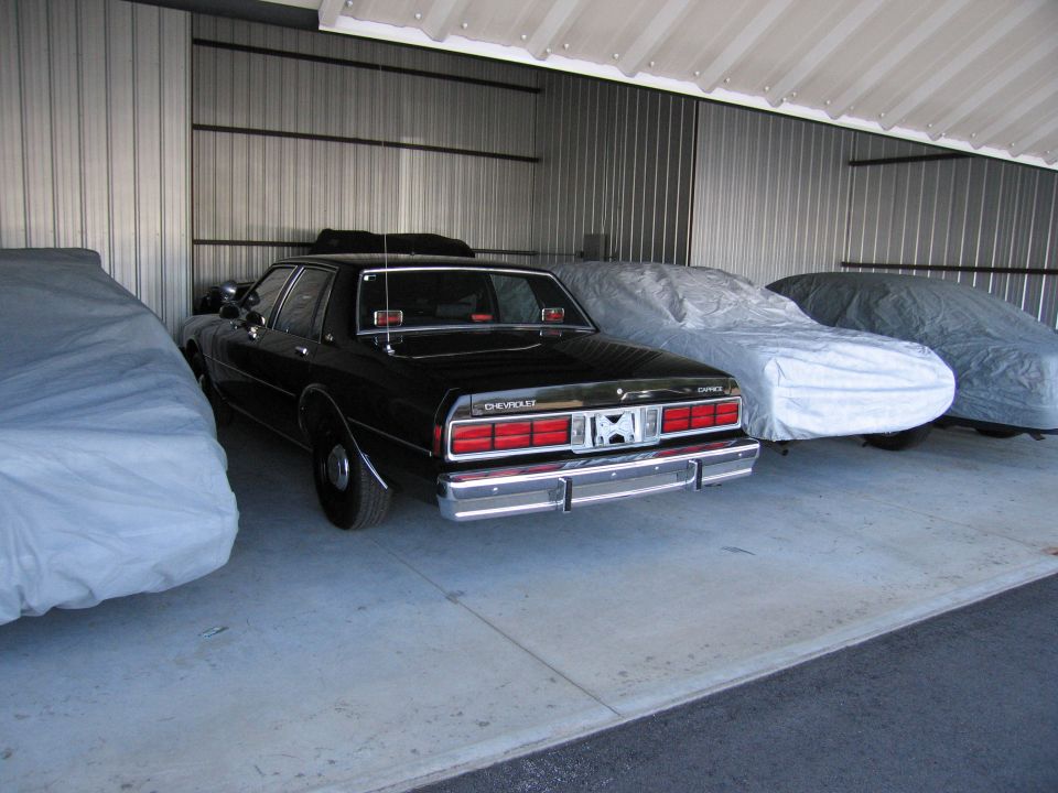 Rear view of a black Chevrolet Caprice sedan parked indoors