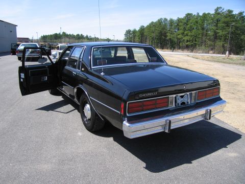 1991 Ford LTD Crown Victoria - This Chevrolet sedan, likely from the early 1980s, is parked outdoors with its driver's side door ajar.