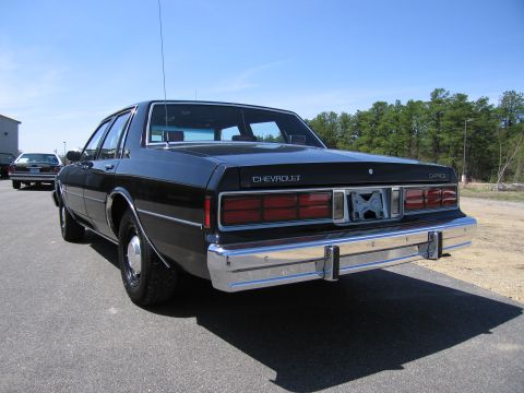 1991 Ford LTD Crown Victoria - Rear view of a black Chevrolet Caprice sedan with chrome bumper and taillights.