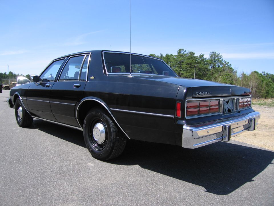 Black Chevrolet sedan, rear quarter view. Shows Chevrolet badge on trunk