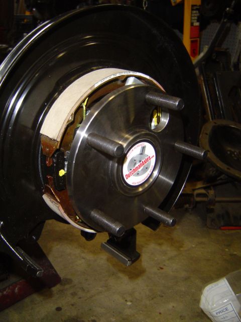 1989 Ford Bronco - Close-up of a vehicle's axle hub and brake assembly, with visible brake shoes and a brand sticker.