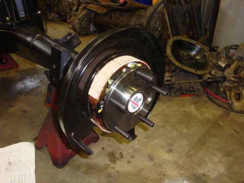 1989 Ford Bronco - A vehicle's axle assembly, a brake rotor and drum, is shown in a workshop setting.