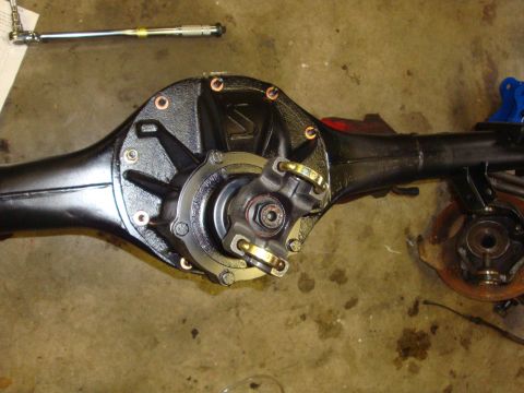 1989 Ford Bronco - Close-up of a vehicle's differential and driveshaft assembly, with a torque wrench in the background.