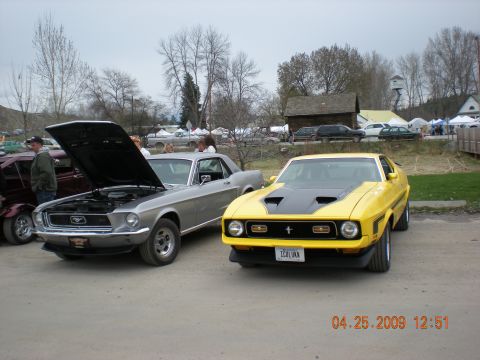 1974 Ford Ranchero - A yellow 1971 Ford Mustang is parked next to a silver car with its hood open.