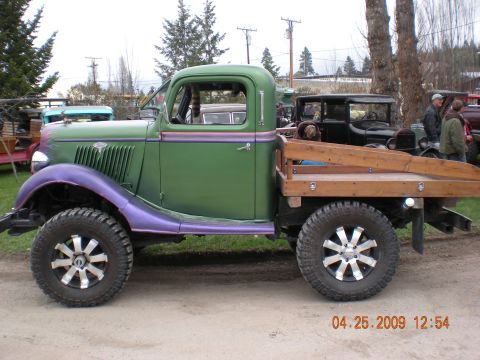 1974 Ford Ranchero - This vintage truck features a flatbed with wooden sides and distinctive purple fenders.
