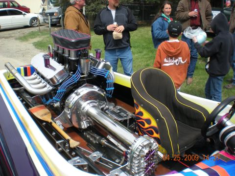 1974 Ford Ranchero - A custom boat's engine and seating area are shown, with onlookers in the background.