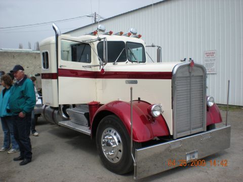 1974 Ford Ranchero - A two-tone semi-truck is parked outside a building with people nearby.