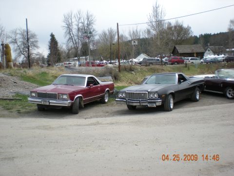 1974 Ford Ranchero - Two classic American utility vehicles, a black Ford Ranchero and a red Chevrolet El Camino, are parked outdoors.
