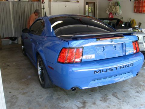 1992 Ford Bronco - Rear view of a blue Ford Mustang with tinted windows and a spoiler.