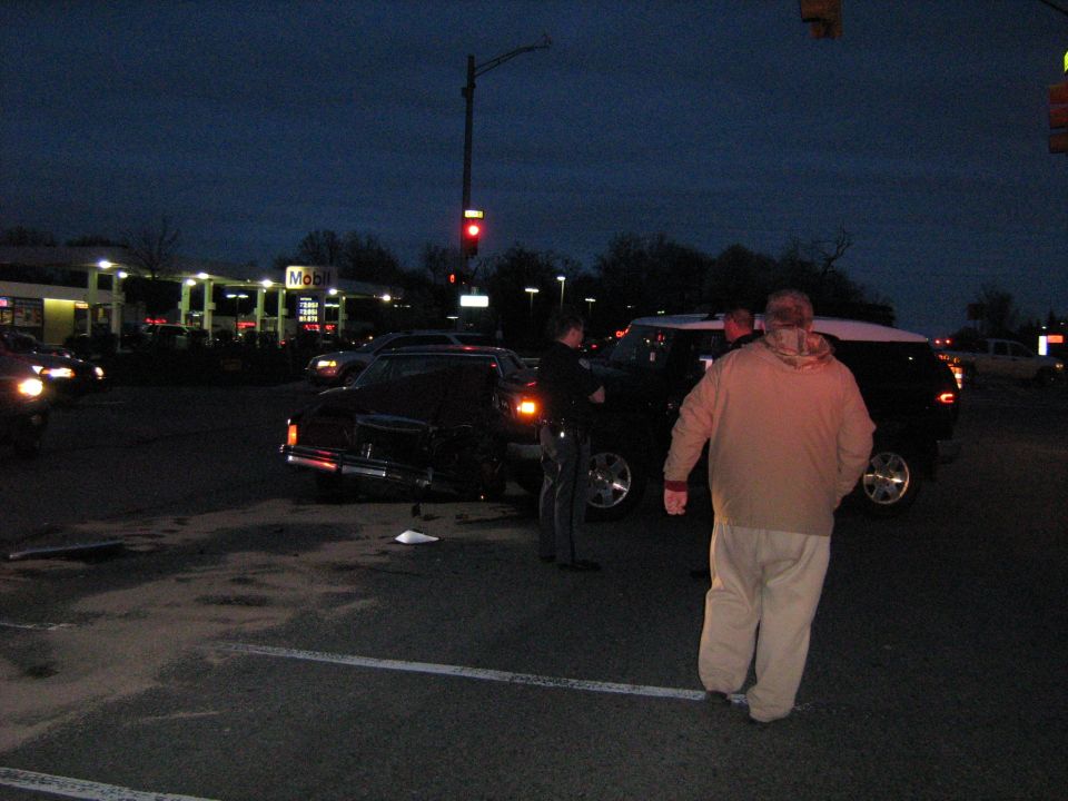 Black sedan and white SUV at gas station, dusk