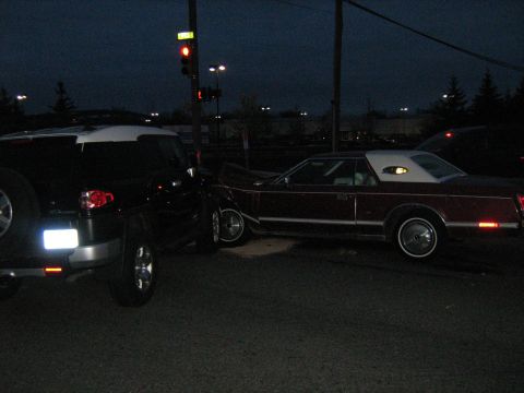 1988 Mercury Grand Marquis - A collision occurred between a black FJ Cruiser and a maroon Lincoln Continental Mark V at a traffic light.