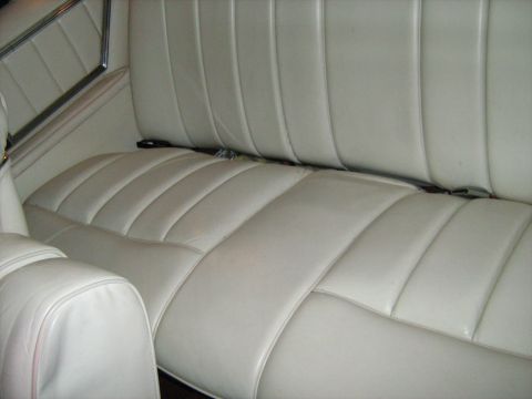 1988 Mercury Grand Marquis - The interior of the vehicle features a white vinyl bench seat with a prominent seam pattern.