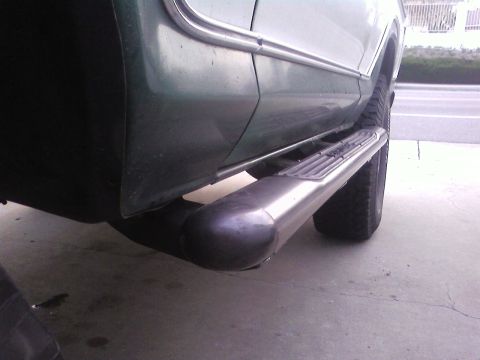 1978 Ford Bronco - A close-up shot focuses on the side step and exhaust pipe of a vehicle parked outdoors.