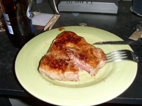 1978 Ford Bronco - A cooked steak sits on a plate, ready to be eaten, with a beer bottle nearby.