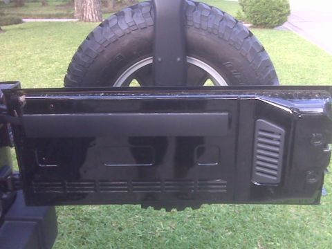 2008 Jeep Wrangler - Rear view of a black Jeep Wrangler showing the spare tire and rear door details.