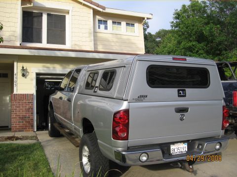 2007 Dodge 2500 - Rear view of a silver pickup truck with a camper shell, parked in front of a house. License plate and date visible.