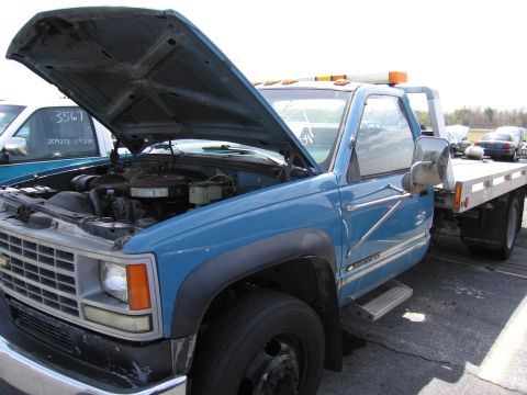 2001 Ford Crown Victoria - Tow truck with its hood open, parked outdoors. Another vehicle is visible in the background.