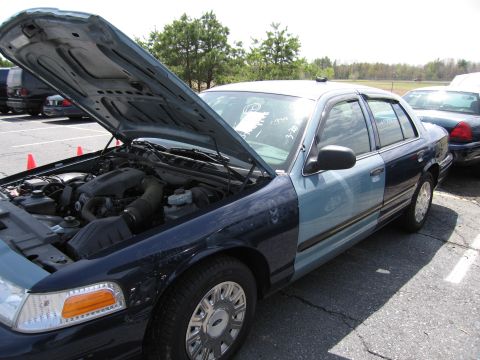 2001 Ford Crown Victoria - A two-tone Ford Crown Victoria with its hood open, parked outdoors next to another vehicle.