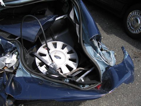 2001 Ford Crown Victoria - Trunk of a 2001 Ford Crown Victoria with visible damage and spare tire.