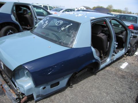 2001 Ford Crown Victoria - This car is missing many exterior and interior components, indicating it is being dismantled or has been stripped for parts.