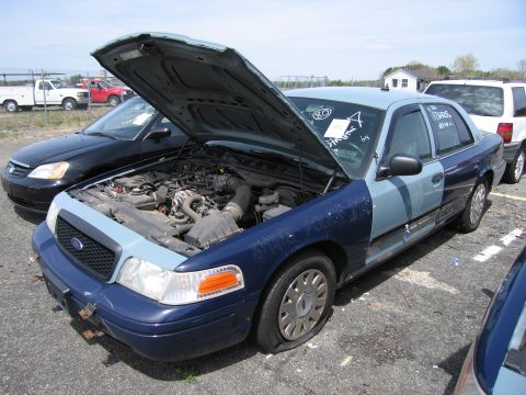2001 Ford Crown Victoria - This 2001 Ford Crown Victoria has its hood open and a flat tire. The car has two-tone blue paint.