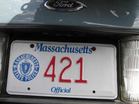 2001 Ford Crown Victoria - Rear view of a Ford vehicle showing the emblem and a Massachusetts State Police license plate.