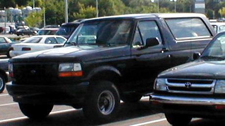 1983 Ford Bronco - This black Ford Bronco is parked in a lot, showing its front 3/4 view.