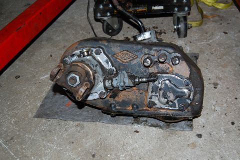 1994 Ford Bronco - A used transfer case, likely from a 4x4 vehicle, sits on a garage floor.