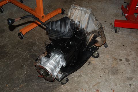 1994 Ford Bronco - A transmission and transfer case assembly sits on a stand, ready for installation or repair.