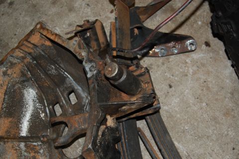 1994 Ford Bronco - Close-up of a heavily rusted metal assembly, likely a vehicle part, with visible wires and bolts.