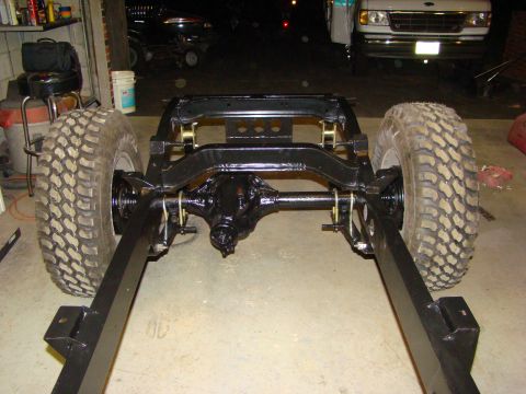 1948 Jeep Wrangler - The frame of a vehicle, including the rear axle and tires, is shown in a workshop setting.
